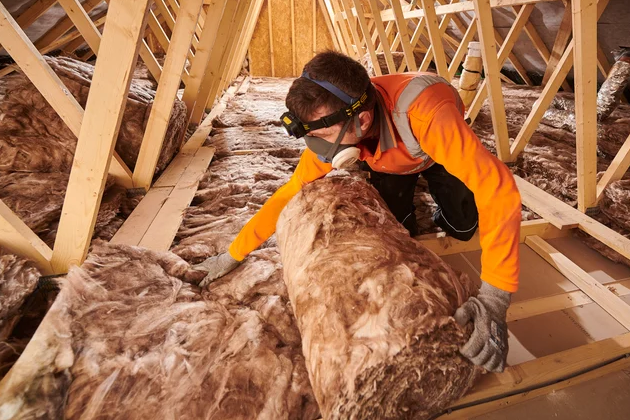 Contractor installing Knauf ECOSE mineral wool loft insulation